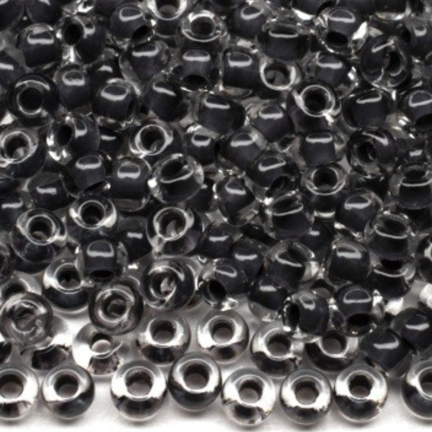 10/0 38349 Preciosa cseh üveg magtartalmú gyöngyök (kásagyöngy) Rocailles 2,3 mm. Kristály színű fekete vonalazással.