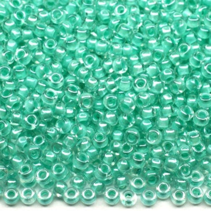 10/0 38653 Preciosa Čekiško Stiklo Karoliukai Rokajaus 2,3 mm. Krištolo Spalvos Su Žaliu Vidumi Sfinx.